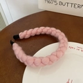 Handmade pink wool braided headband with vintage twist design on a white ceramic plate - Pink