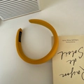 Close-up of yellow fabric padded headband with Hand Made label on a minimalist desk - Ginger Yellow