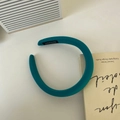 Blue sponge headband with fabric texture and handmade label on a minimalist white desk - Green