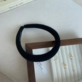 Detail of a thick black padded sponge headband with handmade label on a stylish tray - Black