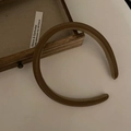 Dettaglio del cerchietto imbottito in pelle marrone con fodera antiscivolo e design retrò - Caffè Scuro