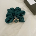 Eleganter dunkelgrüner Satin-Haargummi mit goldumrandetem grünem Kleeblatt auf weißem Papier - Dunkelgrün
