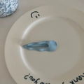 Pince à cheveux ondulée bleu clair mat pour femme présentée sur un plat céramique - Clip Bec de Canard Vague