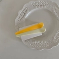 Detail von gelben und beigen matten Macaron-Haarspangen auf weißem Porzellan - Gelb