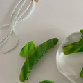 Dettaglio della molletta per capelli in acetato verde marmorizzato su un piatto di ceramica - Pinza a Granchio Lunga Curva