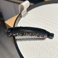 Detail view of black banana hair clip with purple rhinestones and non-slip inner teeth - Purple