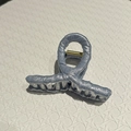 Detailed view of light blue fabric wrapped hair claw clip with golden metal spring - Small / Light Blue