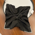 Elegant black satin hair tie with white pearl border details on a woven tray - Black