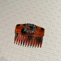 Detail of tortoiseshell hair comb with rectangle silver crystal buckle on checkered background - Coffee Polka Dot