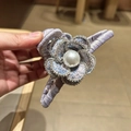 Dettaglio del fermaglio per capelli a camelia viola con perla centrale e strass - Viola 13cm
