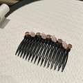 Detail van roze kristallen kralen en visbedels op een zwarte haarkam accessoire - Roze