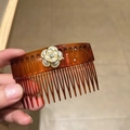 Close-up of amber translucent hair comb featuring a white camellia flower with pearl luster - Coffee Camellia