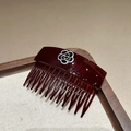 Detailed close-up of dark red resin hair comb featuring black and white camellia flower - Burgundy
