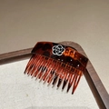 Detail view of tortoiseshell resin hair comb featuring an elegant black and white camellia - Dark Coffee Tortoise