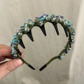 Détail montrant les cristaux colorés et le peigne noir sur le bandeau en tissu - Vert