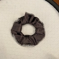 Macro shot of dark brown satin scrunchie with detailed greyish translucent bead edges - Camel