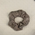 Detailed close-up of champagne satin scrunchie with sparkling hand-sewn crystal beads edge - Purple