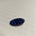Vista macro di un fermaglio ovale con trama in marmo blu e strass di cristallo incastonati - Blu