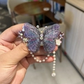 Dettaglio del fermaglio per capelli a farfalla ricamato viola con nappe di perle e strass - Viola