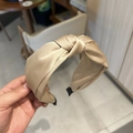 Detailed view of champagne gold satin knotted headband with soft texture and protective tips - Khaki