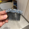 Detalle de un peine para el cabello con cristales facetados azules y púas de metal negro - Azul claro