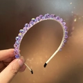 Gros plan détaillé du serre-tête en perles violettes irisées avec base tissée élégante - Violet Métallique
