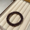 Close-up of a deep purple faceted crystal hair tie displayed in a beige velvet jewelry box - Purple
