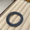 Dettaglio dell'elastico per capelli in cristallo blu con perline in un vassoio per gioielli - Azzurro