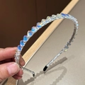 Detailaufnahme des schillernden Kristall-Blumenstirnbands mit elegantem Metallsockel - Meerjungfrau Weiß