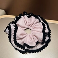 Detail van een pluizige roze-paarse chiffon haarelastiek met zwarte fluwelen rand - Roze