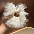 Dettaglio di un elastico per capelli grande in pizzo bianco con rete a pois e etichetta artigianale - Bianco Sporco