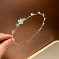 Detalle de diadema metálica dorada con flores azul claro y cuentas en forma de gota - Azul