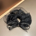 Detail of black mesh hair scrunchie with sparkling beads and a central crystal bow - Black