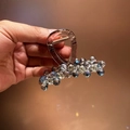 Detail van de blauwe kristallen kralen en de gouden veer op de stijlvolle haarclip van hars - Koningsblauw Klein