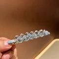 Dettaglio di un fermaglio per capelli con cristalli grigi sfaccettati su base metallica - Azzurro