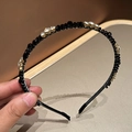 Vue détaillée du serre-tête noir minimaliste orné de strass étincelants et de perles minérales - Noir