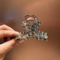Dettaglio della lussuosa clip per capelli con cristalli colorati e strass scintillanti - Sfumato