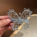 Detalle de pinza para el cabello de mariposa tejida con cuentas de cristal y base de terciopelo - Azul claro