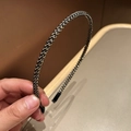 Dettaglio di un cerchietto sottile intrecciato con texture a spirale nero e oro - Nero