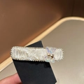 Dettaglio del fermaglio per capelli con perle, strass lucidi e orsetto in resina - Bianco