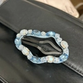 Detail view of cloud-shaped hair clip with light blue gems and rhinestones on black leather - Cloud Blue