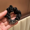 Dettaglio di un elastico in raso nero con perle di cristallo grigie su tessuto morbido - Scrunchie Perline Tonde