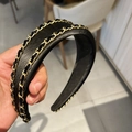 Detail eines schwarzen Kunstleder-Haarreifens mit zwei goldfarbenen Kettenverzierungen - Schwarz