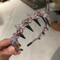 Detail shot of elegant purple crystal flower headband with secure black comb teeth grip - Purple