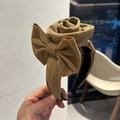 Detail of caramel brown fabric headband with texture and elegant 3D rose flower bow accent - Camel