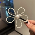 Dettaglio di un fermaglio per capelli a fiore con perle e nastro nero su base in metallo - Stile Perla Bianca