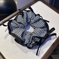 Detalle de coletero con patrón de cuadros y un elegante lazo de satén negro para mujer - Borde Negro Cuadros Lazo