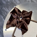 Dettaglio di elastico per capelli in velluto marrone caffè con perle finte su vassoio - Marrone