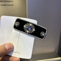 Detail of velvet headband featuring blue gemstone cluster and silver rhinestone edges - Black Hair Clip