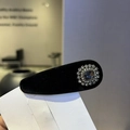 Gros plan d'un serre-tête en velours noir orné d'une élégante fleur en strass cristal - Barrette Goutte d'Eau (A1-107)